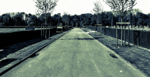 Longue rue calme près d'un cimetière. Long calm road alongside a graveyard / cemetery.